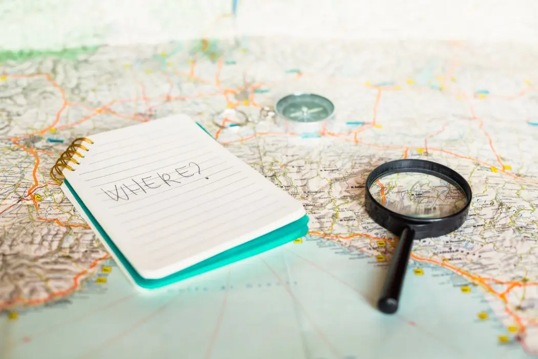 Map and magnifying glass highlighting the need to audit telecom legacy system costs before achieving 60% cost reduction